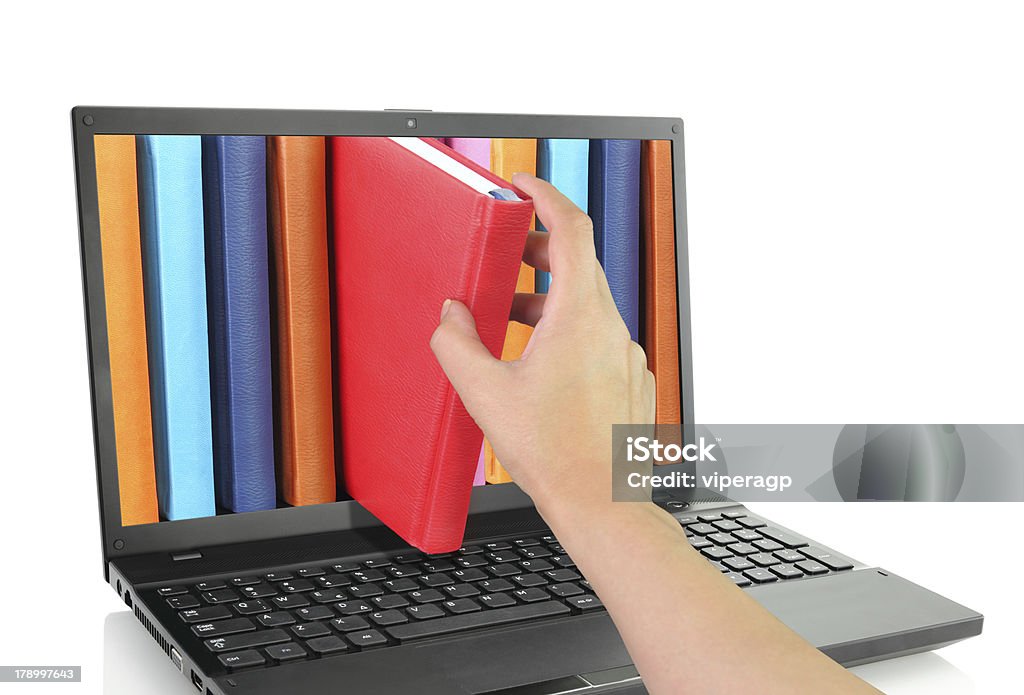 Hand removing a book from notebook screen Laptop computer with colored books E-Reader Stock Photo