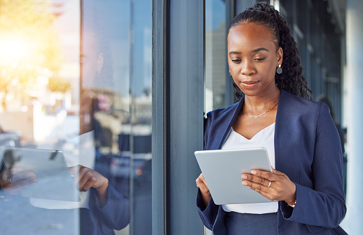 Business, black woman with internet and tablet at window in office, thinking and ideas for online career. Email, digital work and businesswoman with ideas, planning and feedback for internet job.