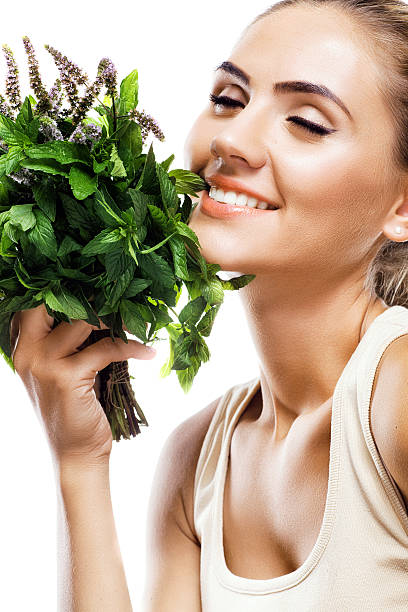 istock woman with bundle herbs (mint). Concept vegetarian dieting - he 178998832