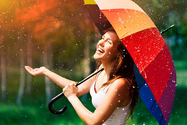 rir mulher com guarda-chuva durante a chuva de verificação - rain women umbrella parasol imagens e fotografias de stock