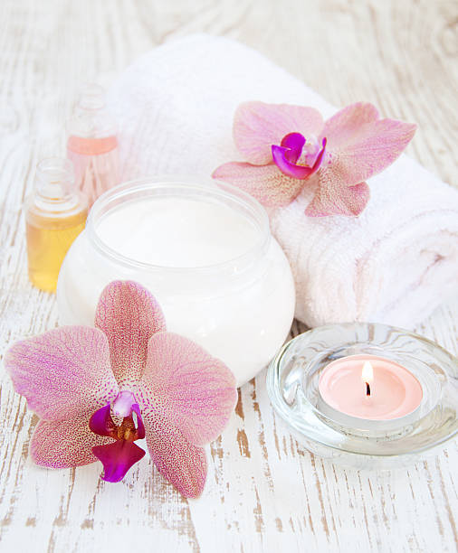 crème hydratante avec orchidées roses - alternative therapy aromatherapy spa treatment candle photos et images de collection