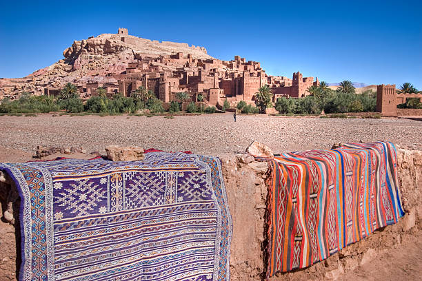 morocco wild  landscape with carpet and ancient ksar palace under a blue sky