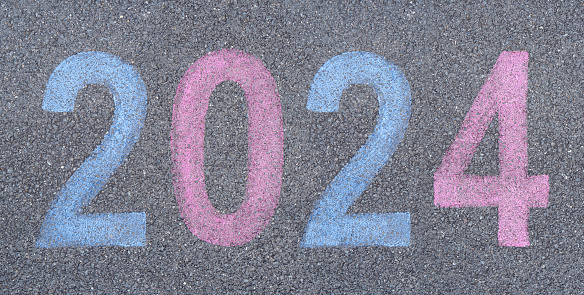 Start the New year 2024 stenciled in pavement paint on the asphalt, start trip concept. Celebration journey into the New Year numbers