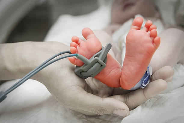 mother's hand holding feet of new born baby sick - kuvös bildbanksfoton och bilder