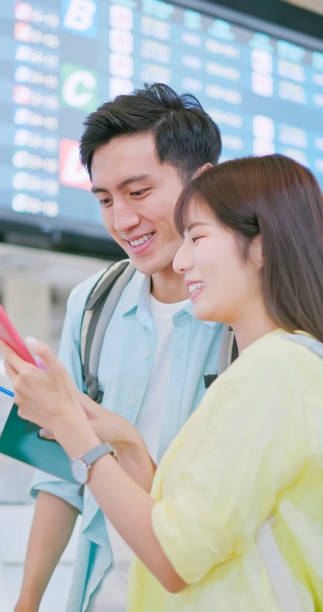 istock Asian couple check flight airport 1790020633