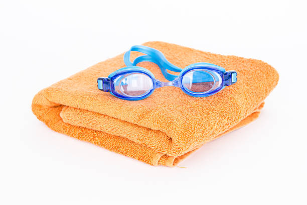 Two pairs of goggles on blue and white towels