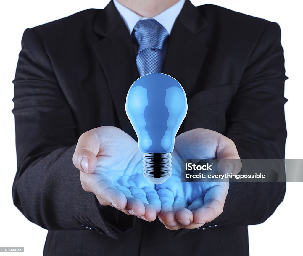 Homme d'affaires main MONTRE bleu Ampoule électrique - Photo de Ampoule électrique libre de droits