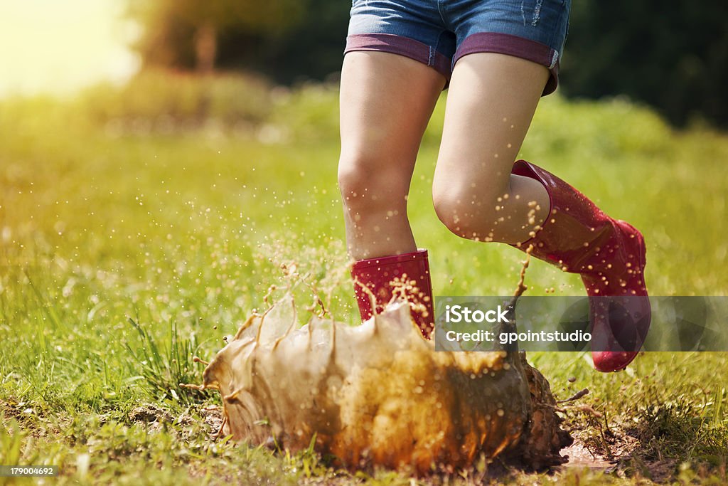 Woman have fun jumping in puddle Women Stock Photo