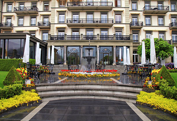 fontana e fiori in primo piano di un bellissimo edificio (svizzera) - fountain landscaped ornamental garden flower bed foto e immagini stock