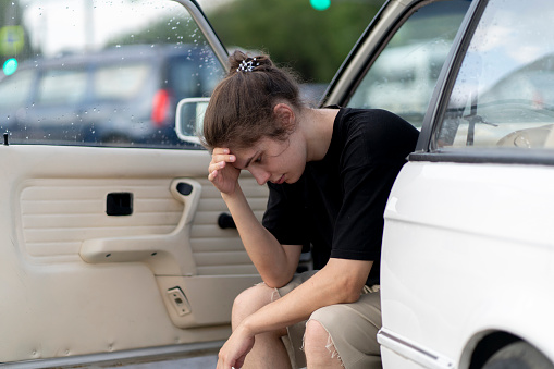 a young male driver feel sad and depressed in the white old car