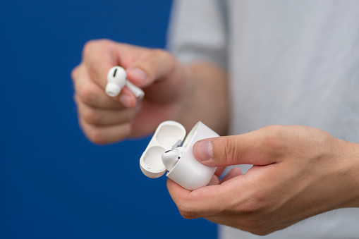 person holding a wireless earbuds case, ready to listen to music