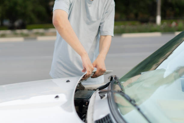 istock young driver has some car problems, open the car hood on a highway 1790055190
