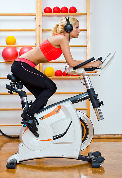 woman on stationary speed bike stock photo