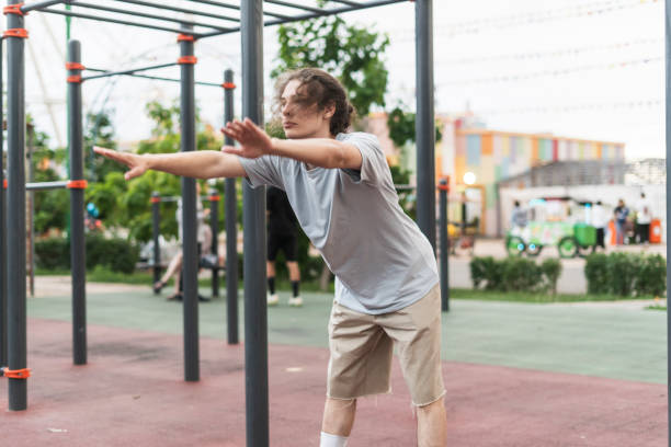 istock man doing sport workout outdoors, stretching his body before practice 1790056804