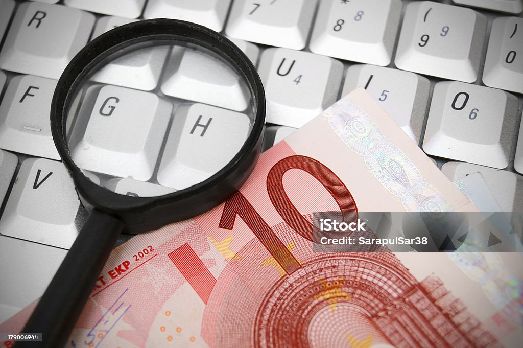 Magnifiers et euro un banknote sur le clavier. - Photo de Affaires libre de droits