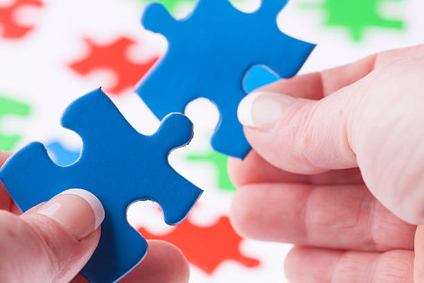 istock Woman hands fitting jigsaw puzzle pieces together 179007788