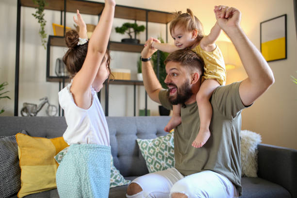istock Young active dad play with daughters in modern room stock photo 1790107559