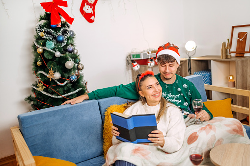Young couple relaxing at home on sofa bed for New Years Eve