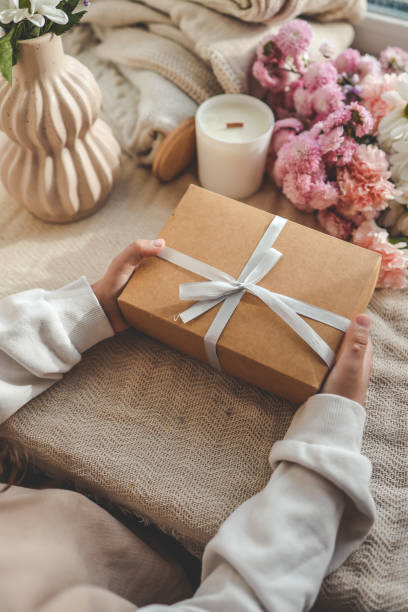 istock Gift box in hands with flowers at home 1790109706