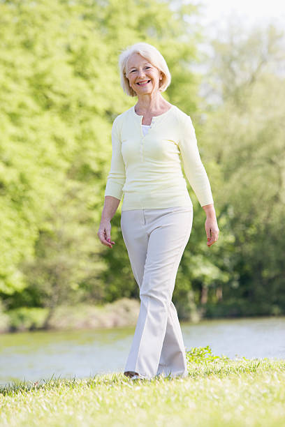 istock Woman walking outdoors at park by lake smiling 179011777