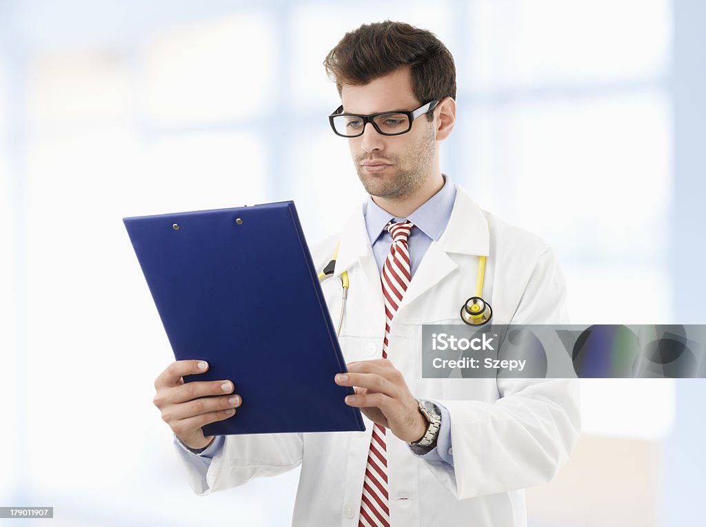 Männlichen Arzt untersuchen medizinischen Bericht - Lizenzfrei Arme verschränkt Stock-Foto