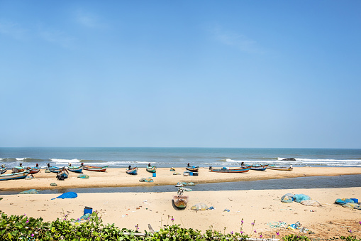 Boats along the shore at the beach in Mahabalipuram, Tamil Nadu, India.