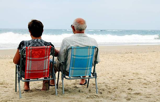 istock backview of senior couple on sandy beach 179014792