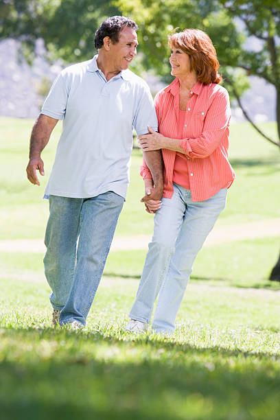 istock Couple holding hands outdoors by lake smiling 179014843