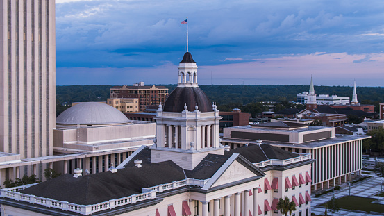 Historical Downtown of Tallahassee, FL with State Capitol stands against the cityscape. First Baptist and Trinity United Methodist Church shown in the distance