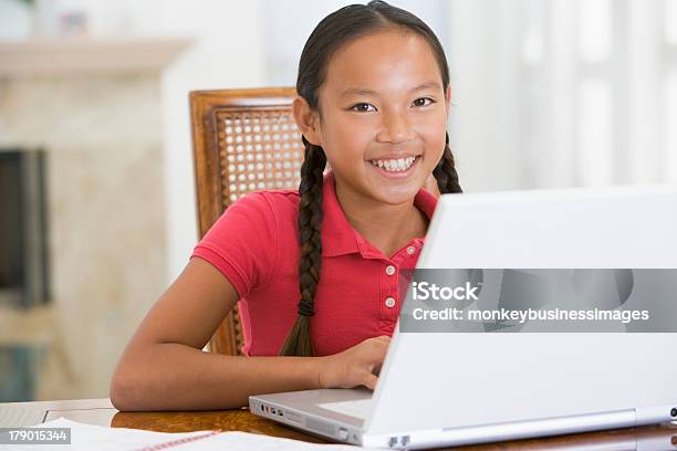 Giovane Ragazza Con Il Portatile In Sala Sorridente - Fotografie stock e altre immagini di Bambino