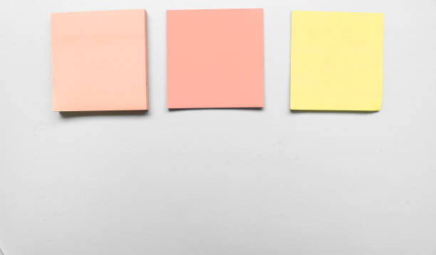 istock Blank three grey colorful sticky notes on gray background. Place for text. Stationery template.Copy space. Sticky note stuck in the middle 1790163532