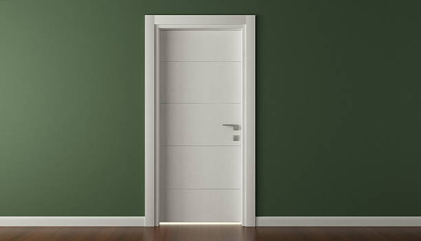 A closed, simple white door in a dark green wall