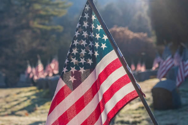 istock American flag background, natural light copy space image, small flags over cemetery thumb stones. 1790175467