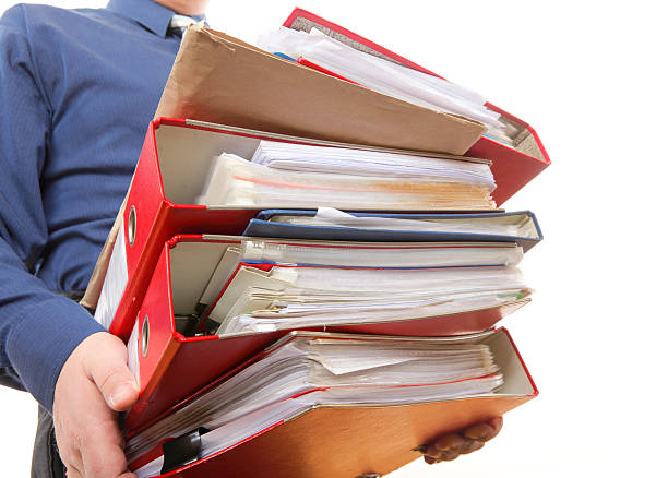 istock Male office worker carrying a stack of files 179018126