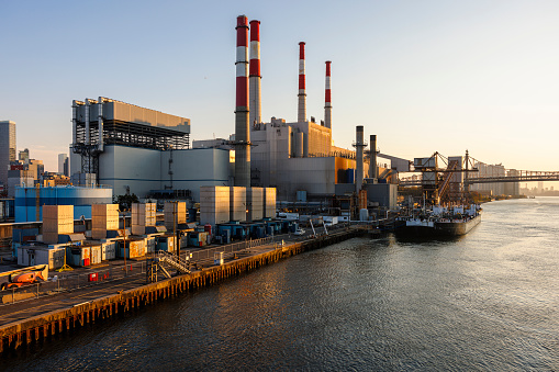 Electrical power plant in Astoria, Queens, on the shore of East River. The fuel is unloading from the moored ship.