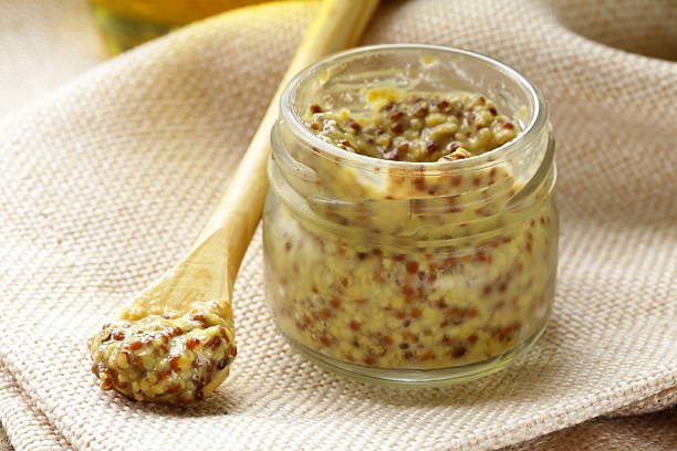 Traditional dijon mustard in a glass jar Traditional dijon mustard in a glass jar dijon stock pictures, royalty-free photos & images