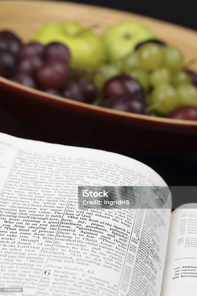 Fruit of the Spirit Holy Bible open to Galatians 5. Focus on verse 22.  Apple - Fruit Stock Photo