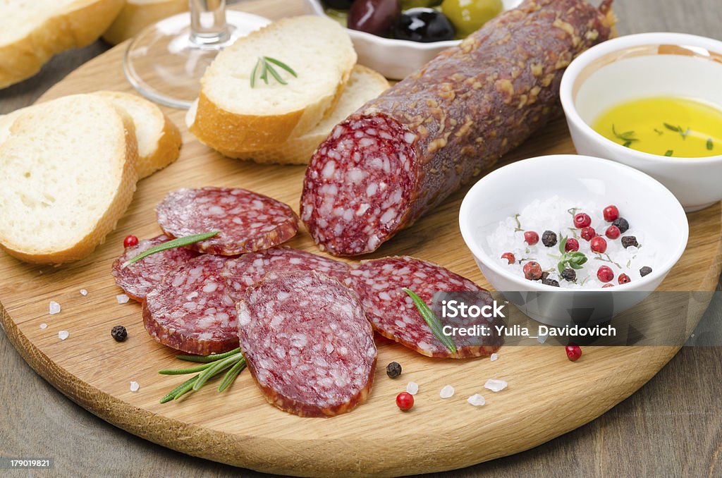 Włoski salami, chleb i przyprawy na pokładzie cięcia - Zbiór zdjęć royalty-free (Antipasto)