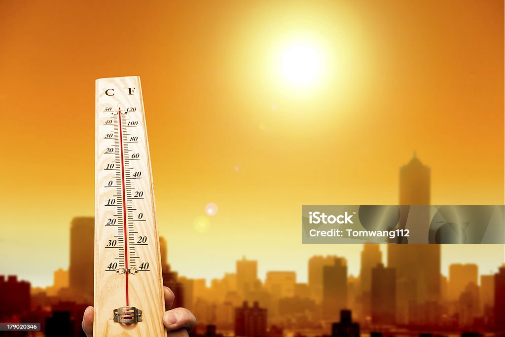 heatwave de la ciudad y el termómetro de mano mostrando - Foto de stock de Calor libre de derechos