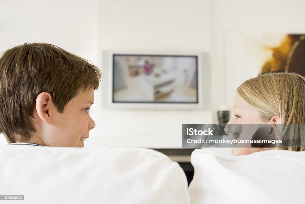 Menino e uma menina na sala de estar com TV - Foto de stock de Assistir TV royalty-free