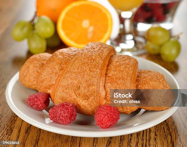 Foto de Croissants Frescos Com Framboesas Em Uma Mesa Marrom e mais fotos de stock de Assar