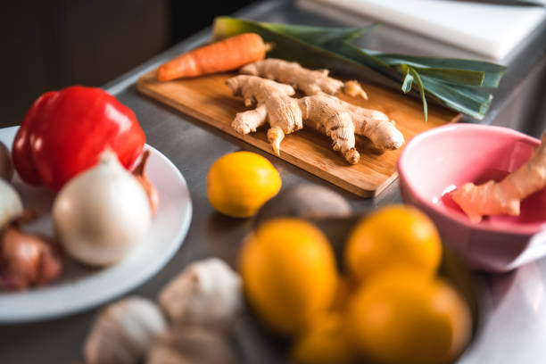 Close-up shot of colorful ingredients for Asian dishes on a kitchen counter. It includes ginger, lemons, red pepper and more.
