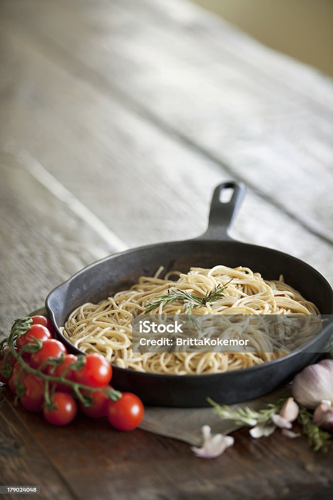 Spaghetti di pasta in una padella di ghisa - Foto stock royalty-free di Aglio - Alliacee
