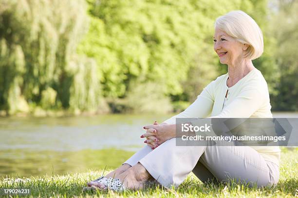 Woman Outdoors At Park By Lake Smiling Stock Photo - Download Image Now - 60-69 Years, Active Seniors, Adult