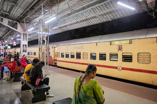 Chennai, India - October 7, 2023. People wait on the train platform at Chennai Central at nighttime.