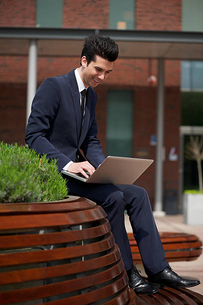 istock Young businessman working on laptop outside the office 179026044