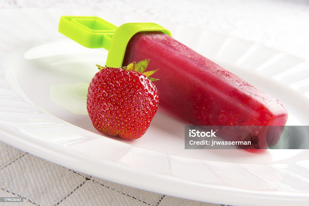 Homemade Strawberry Popsicles! Homemade strawberry popsicle sits on plate  strawberry Flavored Ice Stock Photo