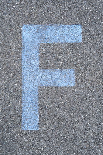 the Letter F are drawn with color paint on asphalt. a children's playground designed a creative display of the alphabet educational element learning space.