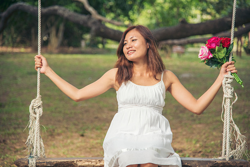 Happy Relax beautiful asian woman smiling face standing in green park outdoors garden. Young women enjoy nature morning Freedom Lifestyle. woman breathing fresh air and relax breath in green park