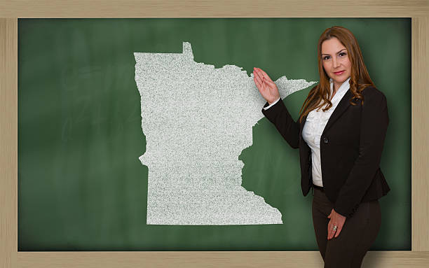 istock Teacher showing map of minnesota on blackboard 179027349
